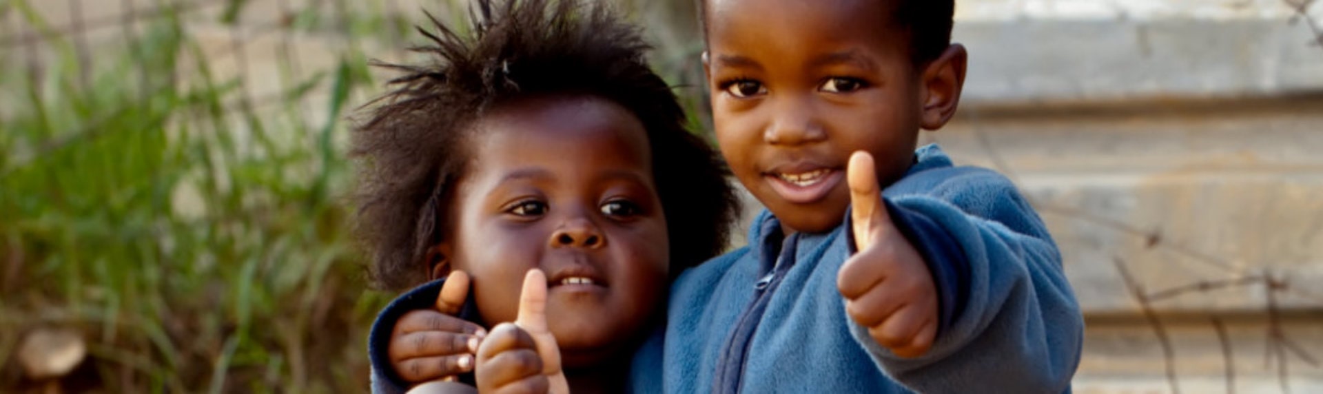 two children giving a thumbs up